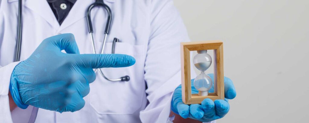 Doctor in gloves holding an hourglass, symbolizing medical billing time limits in California.